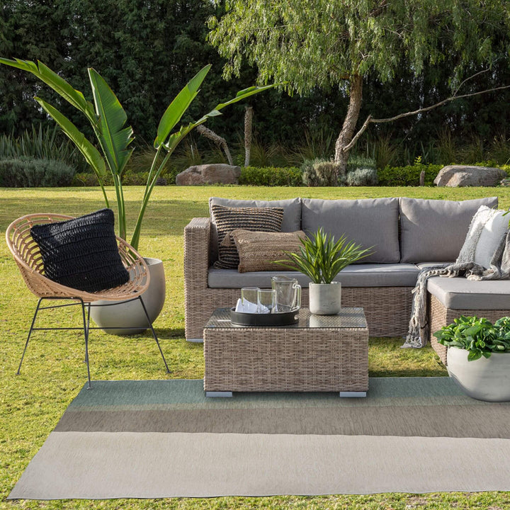 Outdoor lounge area featuring the Capri rug beneath a modular sofa.