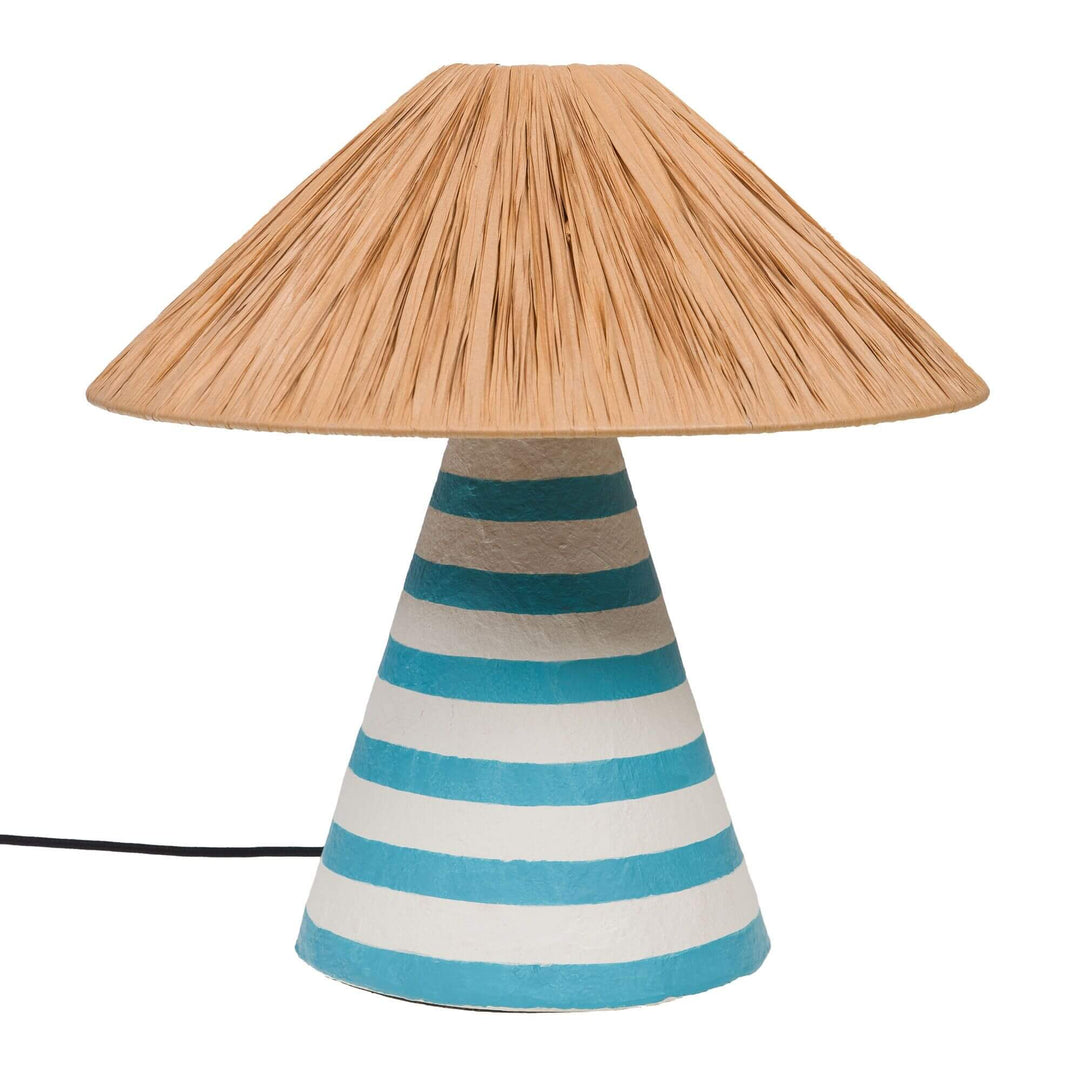Front view of the Capri table lamp showing its turquoise and white striped papier-mâché base and natural fiber shade.
