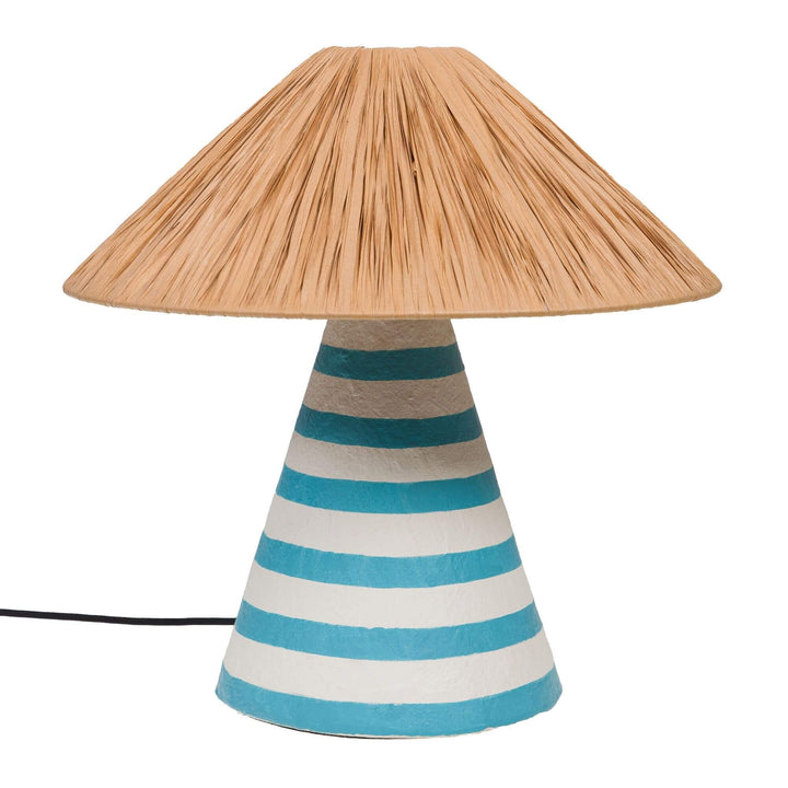 Front view of the Capri table lamp showing its turquoise and white striped papier-mâché base and natural fiber shade.
