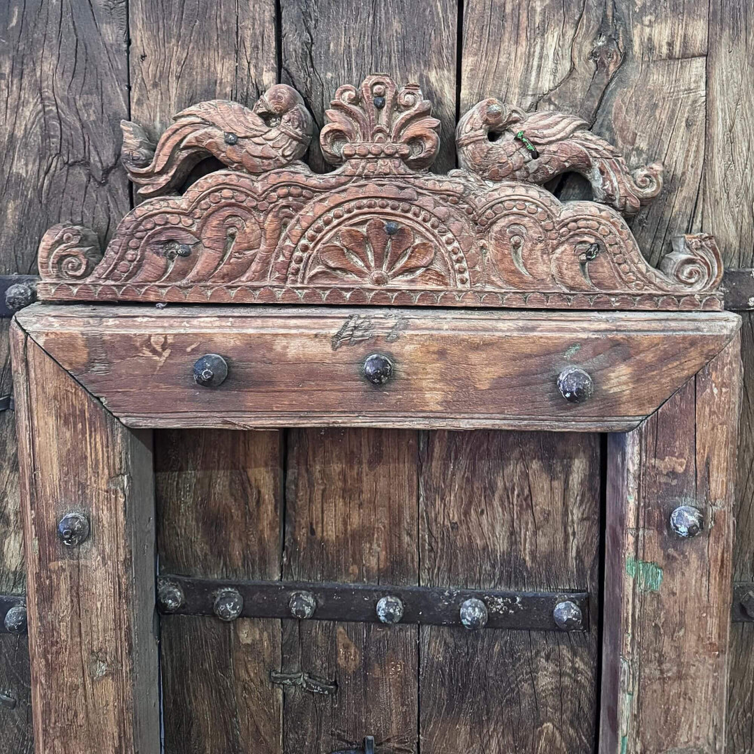 Close-up of the Castle Door highlighting the ornamental carved crest above the smaller integrated door