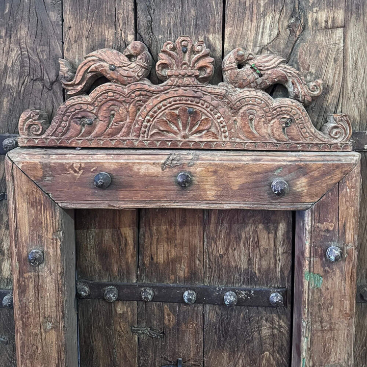 Close-up of the Castle Door highlighting the ornamental carved crest above the smaller integrated door
