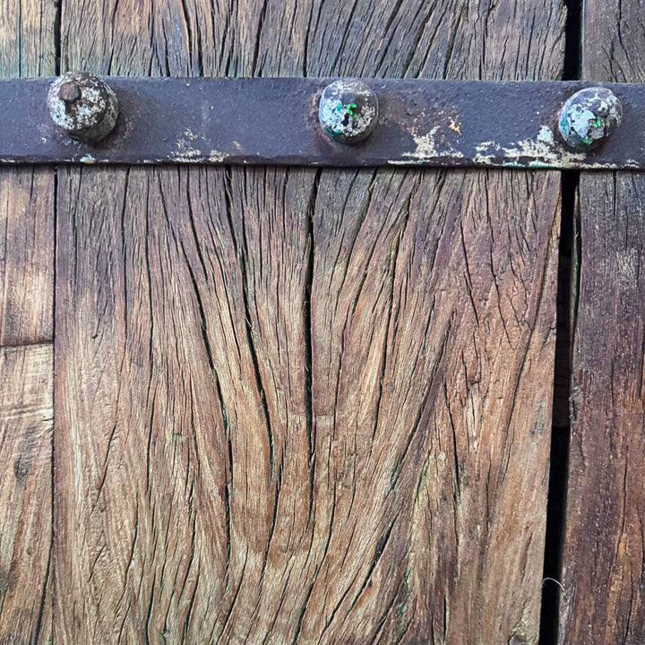 Close-up of the Castle Door highlighting aged wood grain, natural cracks, and dark metal studs