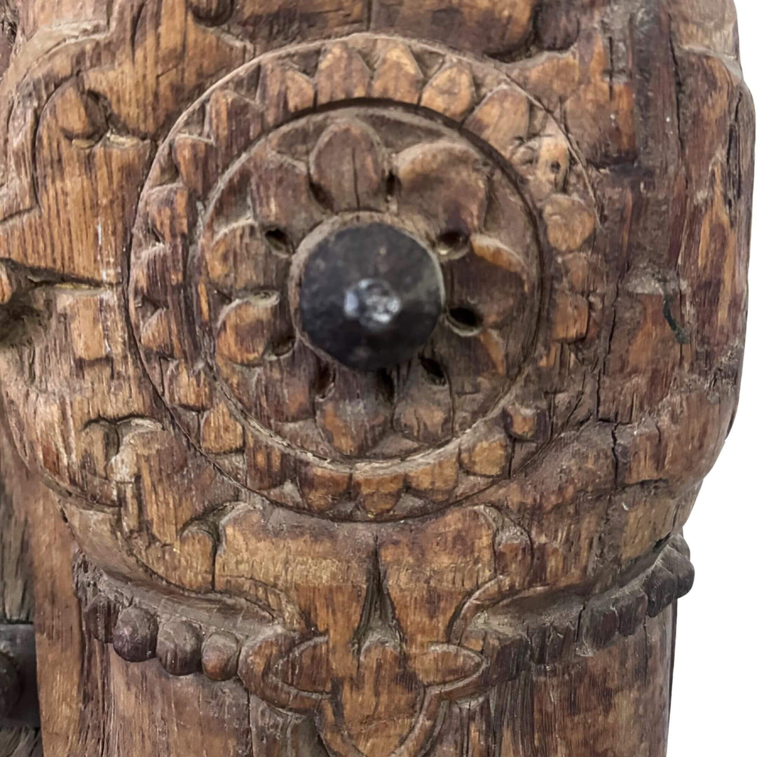 Close-up of the Castle Door showing an intricate floral carving and dark central metal stud