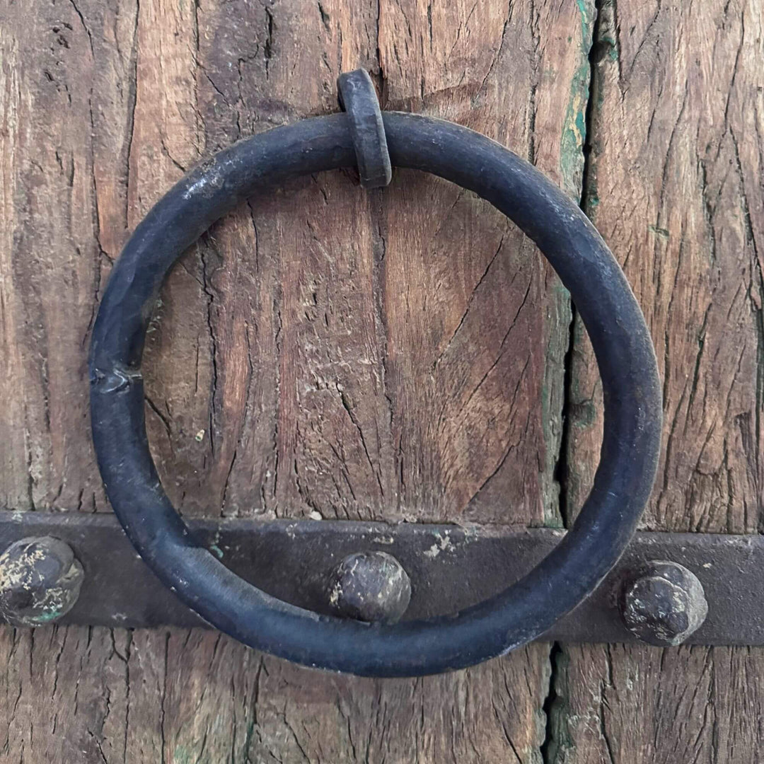 Close-up of the Castle Door highlighting the traditional dark metal ring handle against aged sheesham wood