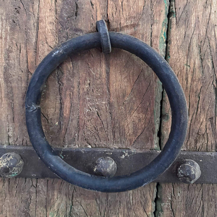 Close-up of the Castle Door highlighting the traditional dark metal ring handle against aged sheesham wood