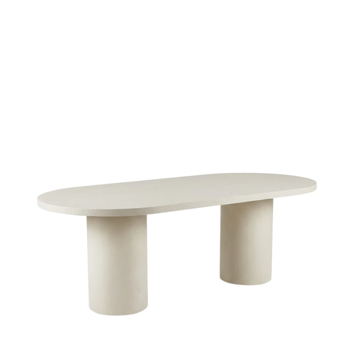 Front view of Cementique microcement oval dining table showing its smooth surface and cylindrical legs.