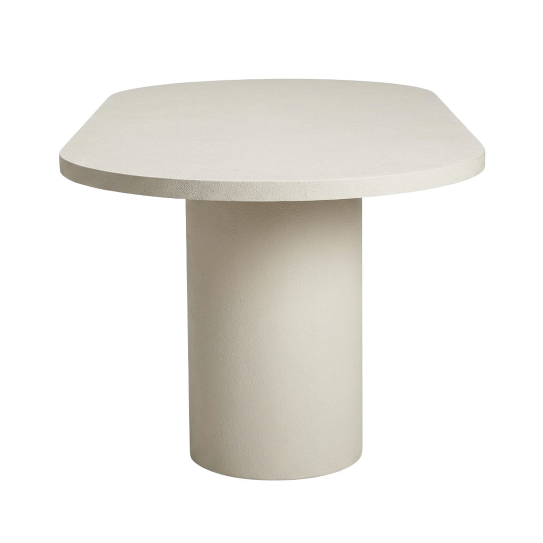 Side view of the oval tabletop highlighting the rounded edges and microcement texture.