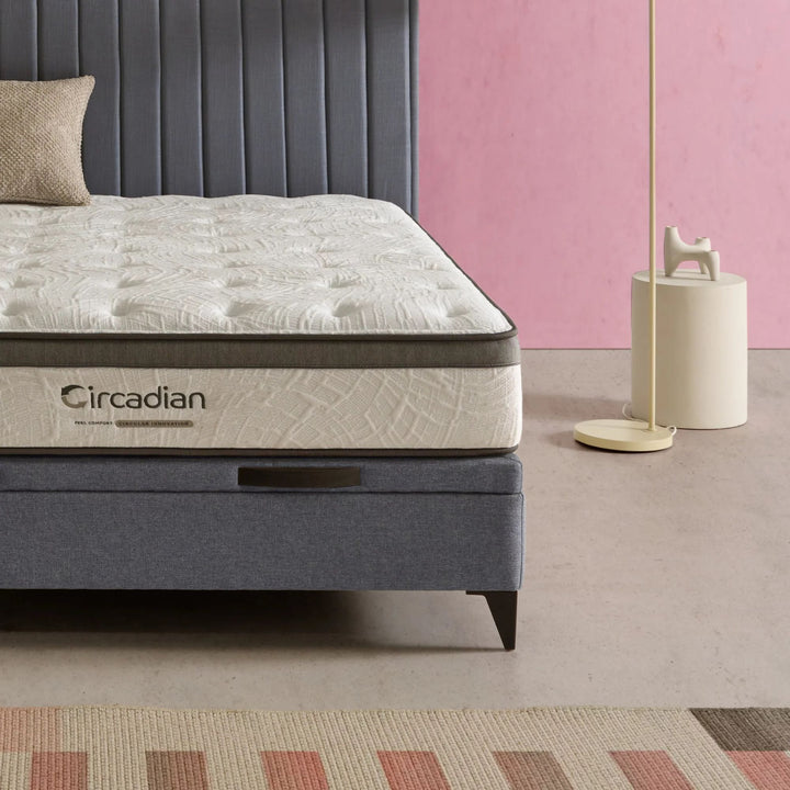 Angled bedroom shot highlighting the mattress profile and premium fabric texture.