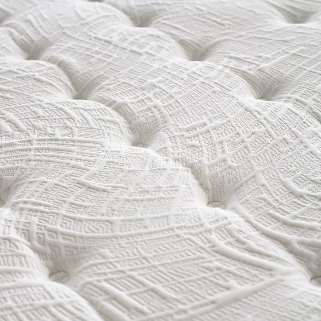 Close-up of the mattress surface showing breathable quilting and detailed stitching.