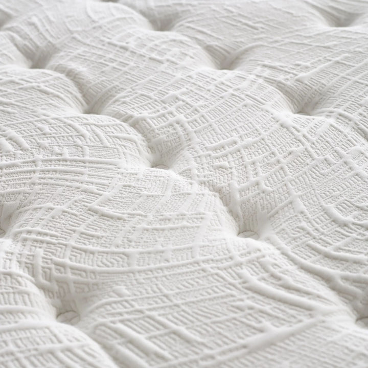 Close-up of the mattress surface showing breathable quilting and detailed stitching.