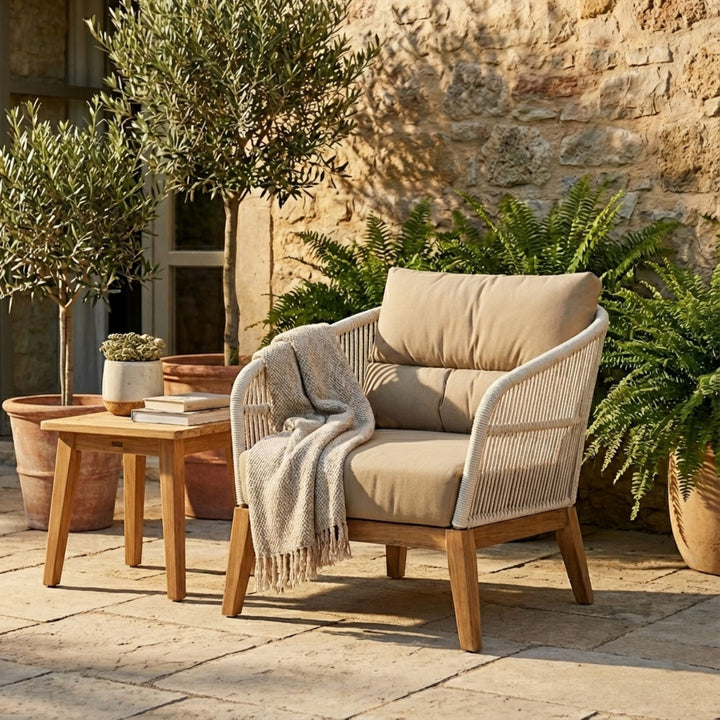 Styled outdoor setting featuring the COCO One Seater Sofa on a stone terrace.