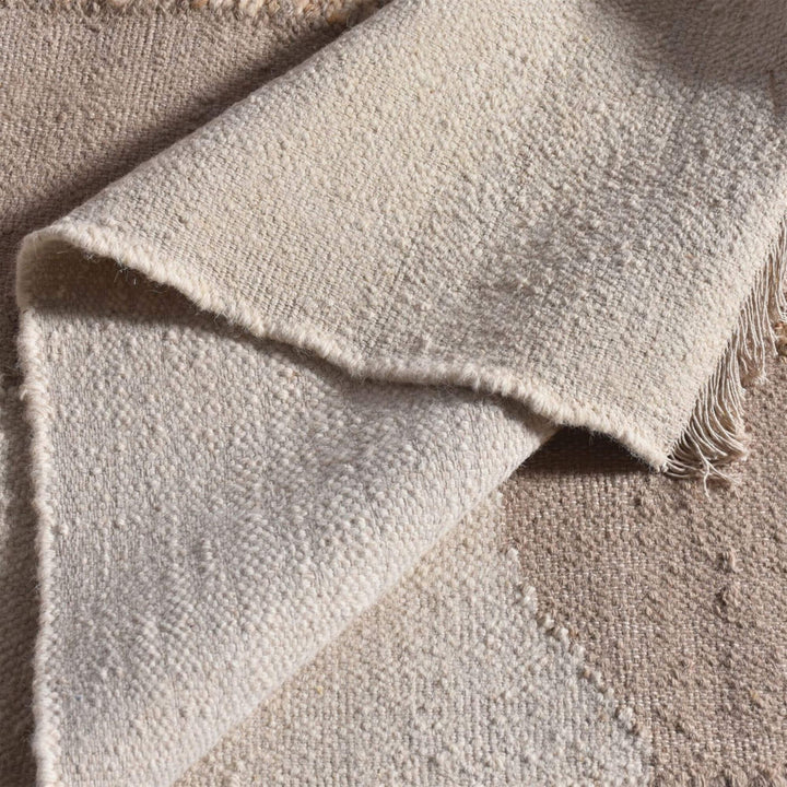 Detail view of the rug edge and thickness showing the soft wool construction.