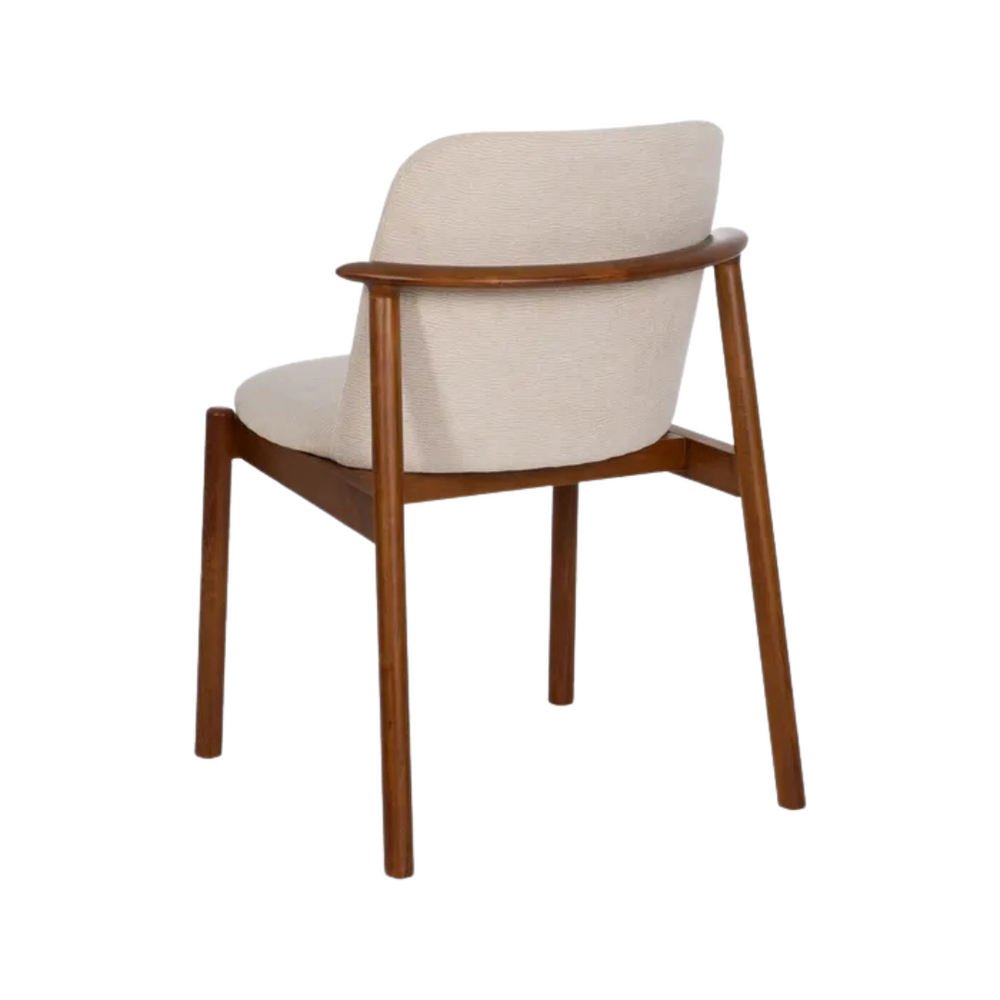 Angled view of Conakri dining chair highlighting soft upholstery and sturdy oak structure.