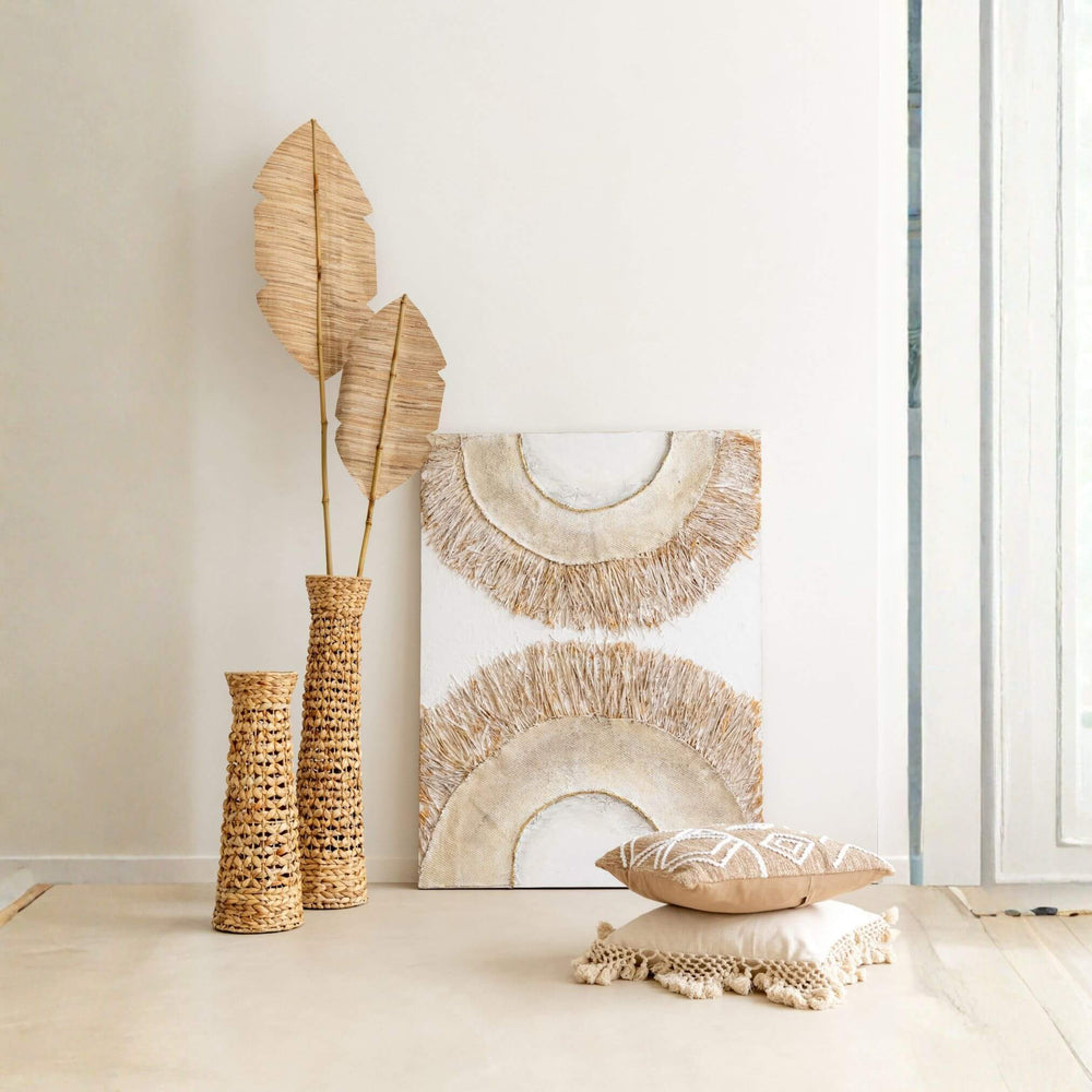 Decorative Creta Painting including a vase with dried leaves, wall art, and pillows on a neutral background