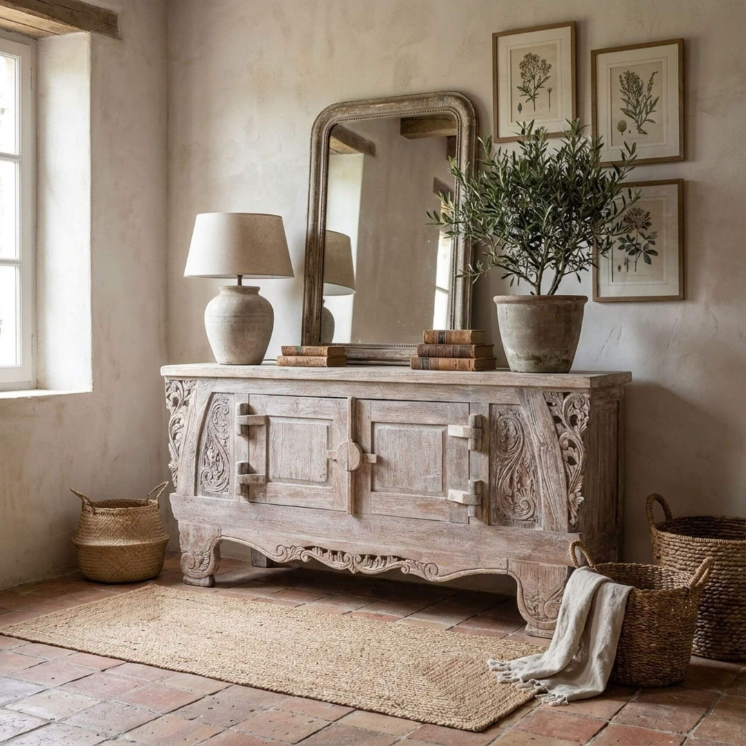 Decorative Dalia carved teak wood buffet table with mirror, lamp, and plant in a rustic room.