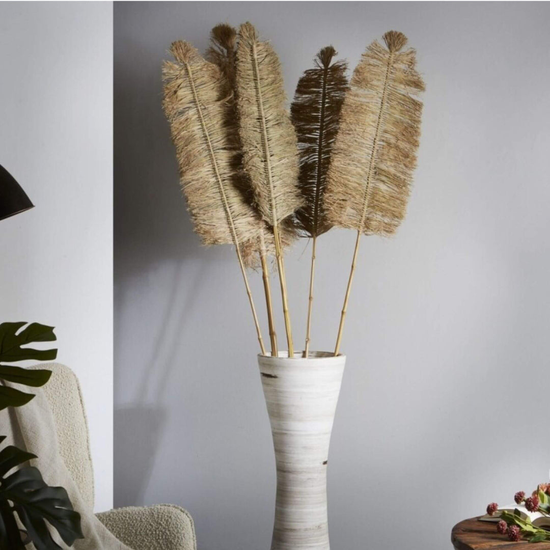 Styled interior scene featuring Deco Palm Panjang arranged in a tall floor vase with multiple stems.