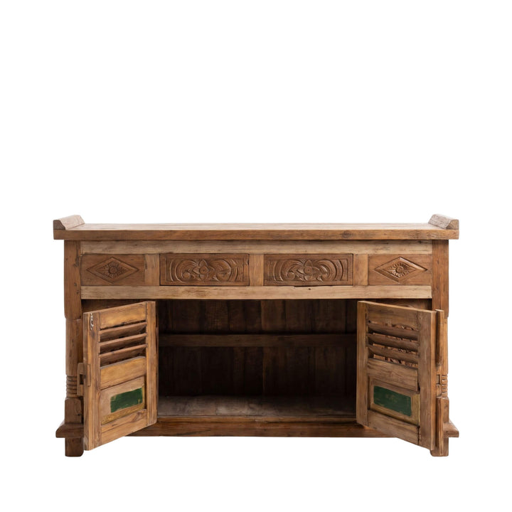 Open cabinet view showing the interior storage space behind the carved teak doors.
