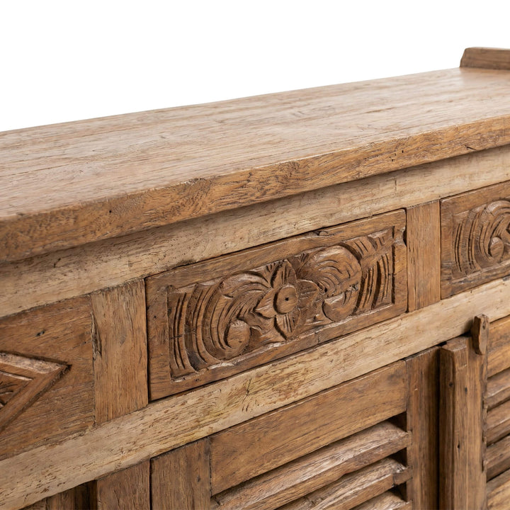 Close-up detail of the carved drawer front and handcrafted wood texture.