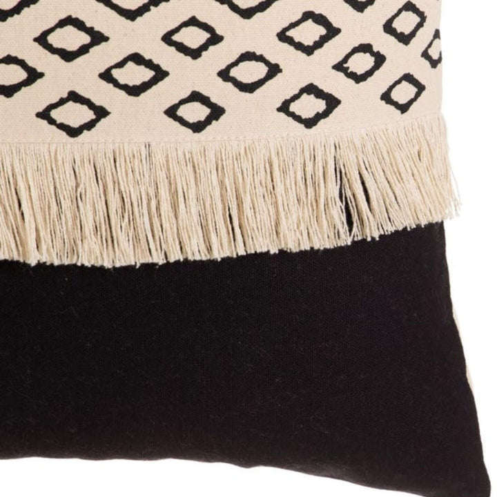 Close-up of fringe detail on beige and black cushion
