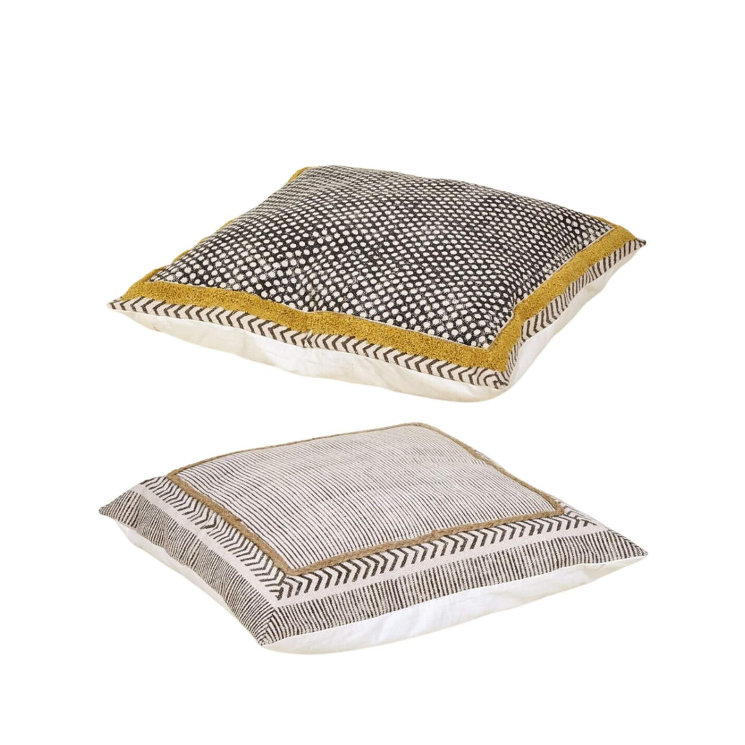 Dhara cushions stacked showing reversible dot and stripe designs with jute trim