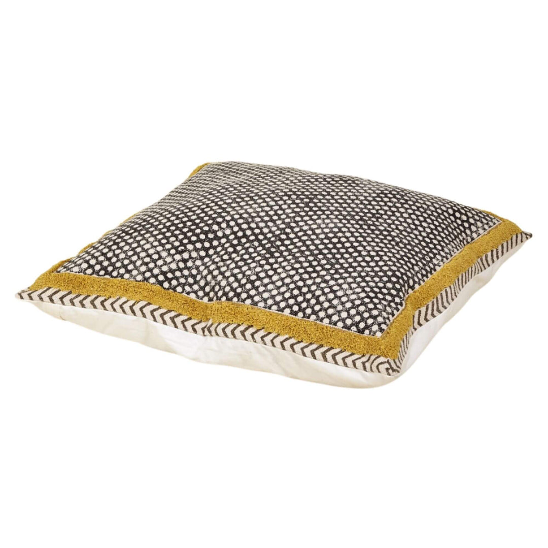 Dhara cotton floor cushion with black dot pattern panel and mustard border on natural base