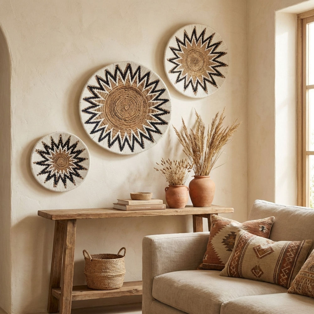 Decorative Diani wall deco plates on a wall above a wooden console table with a sofa and decorative pillows in a room.