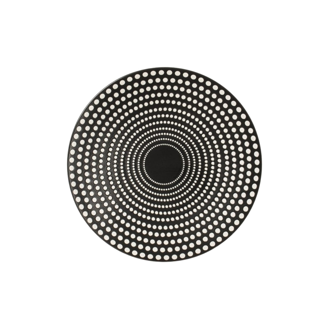 Top view of black ceramic dessert plate featuring concentric dotted design.