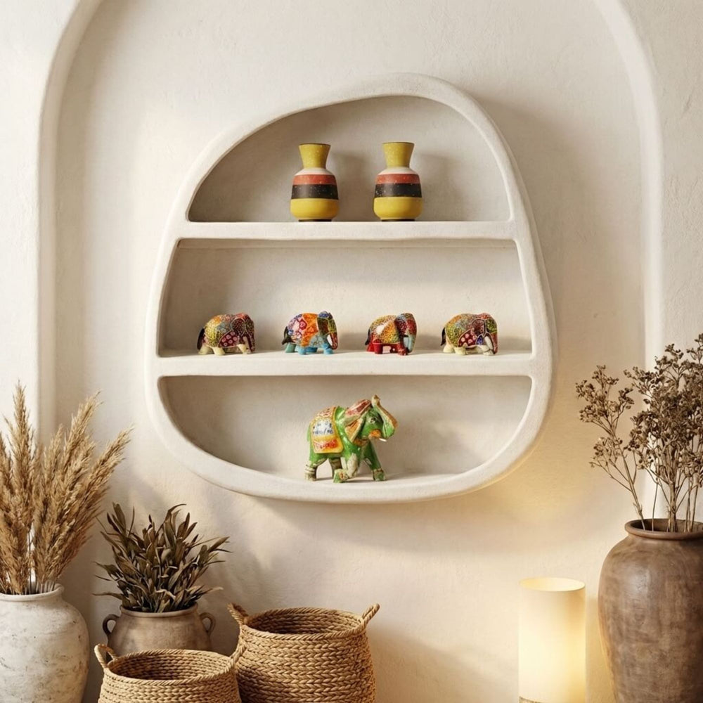 Decorative Dune Wall shelf with small vases and elephant figurines against a white wall.