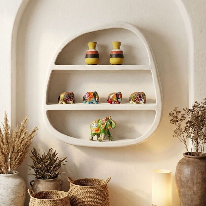 Decorative Dune Wall shelf with small vases and elephant figurines against a white wall.