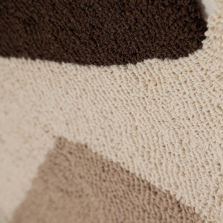 Close-up detail of the fabric surface showing the contrast between dark brown and soft neutral textured areas.