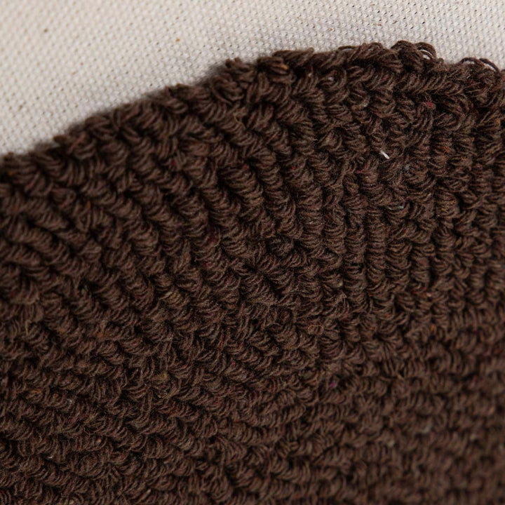 Close-up of the woven brown textile detail showing the handcrafted texture of the artwork.