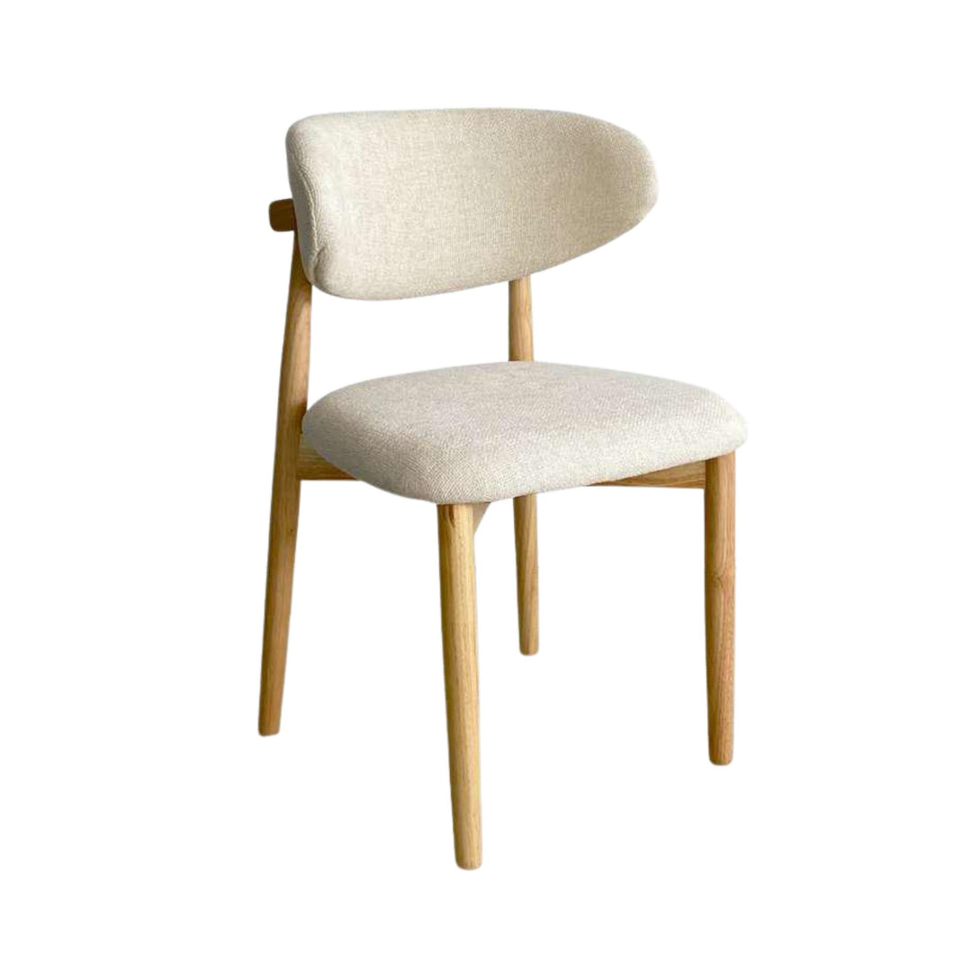 Front view of the Elara dining chair showing its curved upholstered backrest, padded seat, and natural rubberwood legs.