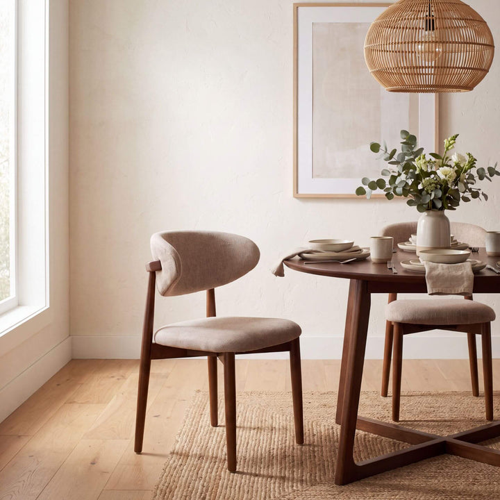 Elara Walnut dining chair styled around a wooden dining table in a warm neutral interior
