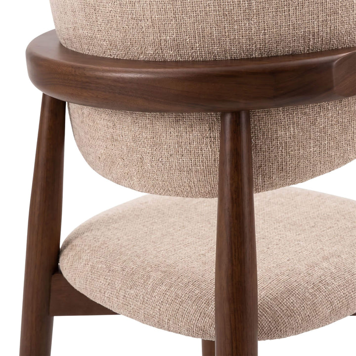Detail of the Elara chair highlighting the sculpted wooden back support and warm walnut finish