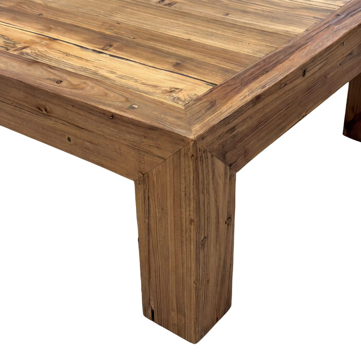 Close-up of the Elm Wood coffee table corner showing its thick top, framed edge, and solid leg
