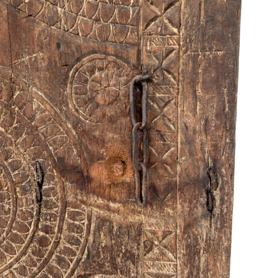 Close-up detail of the carved wood surface with aged patina and texture.