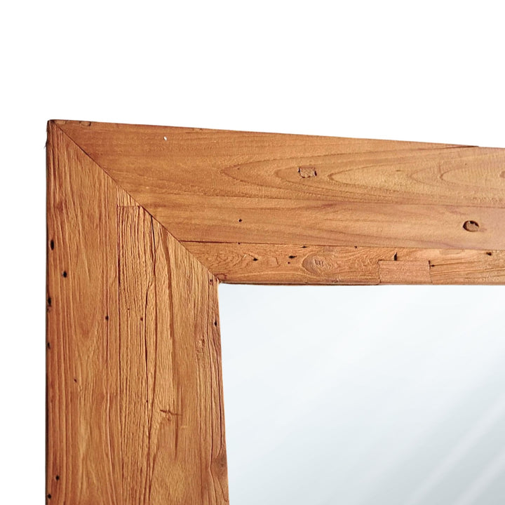 Close-up of natural teak wood grain on mirror frame.