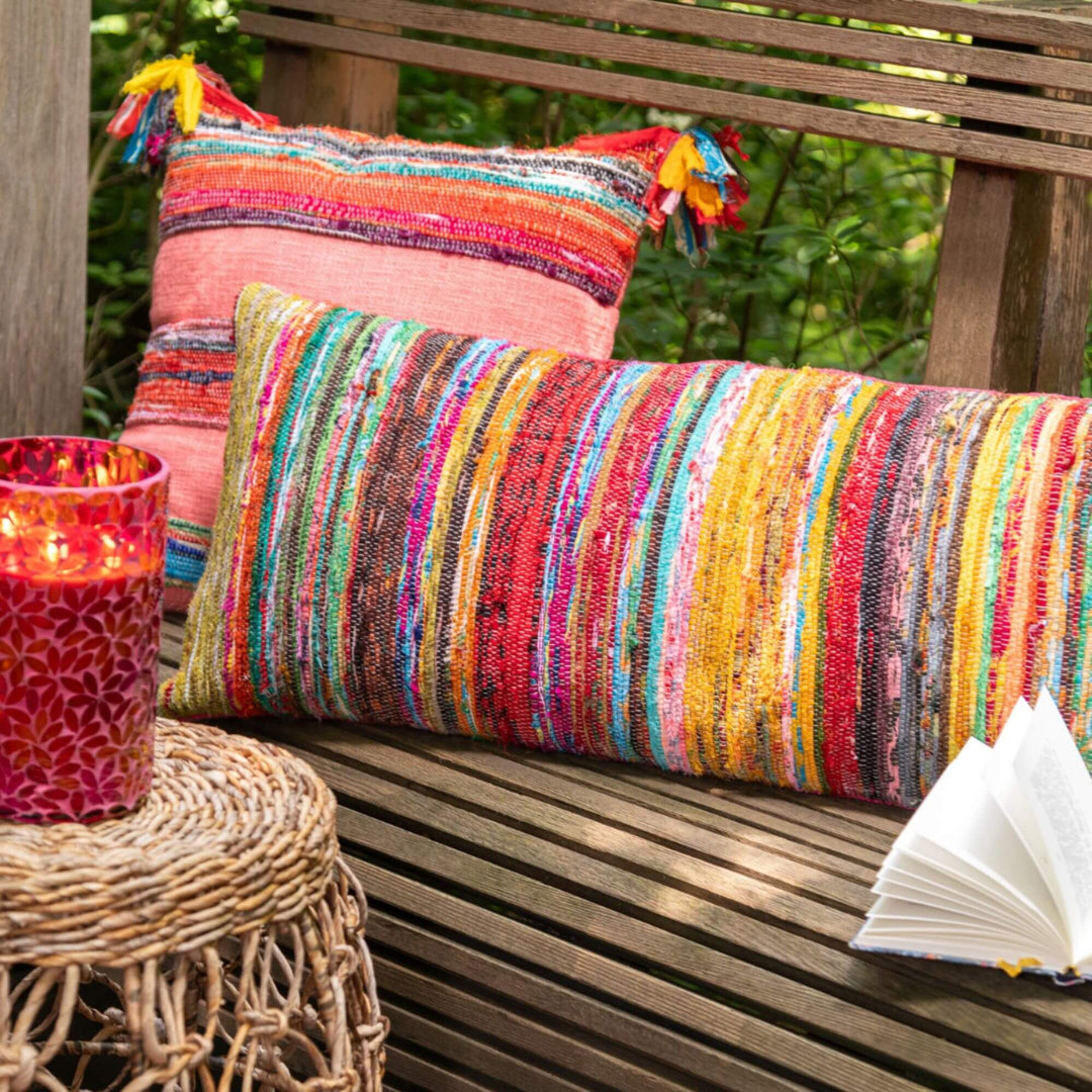 Rectangular multicolor chindi cushion with striped woven texture at an outdoor  living area 