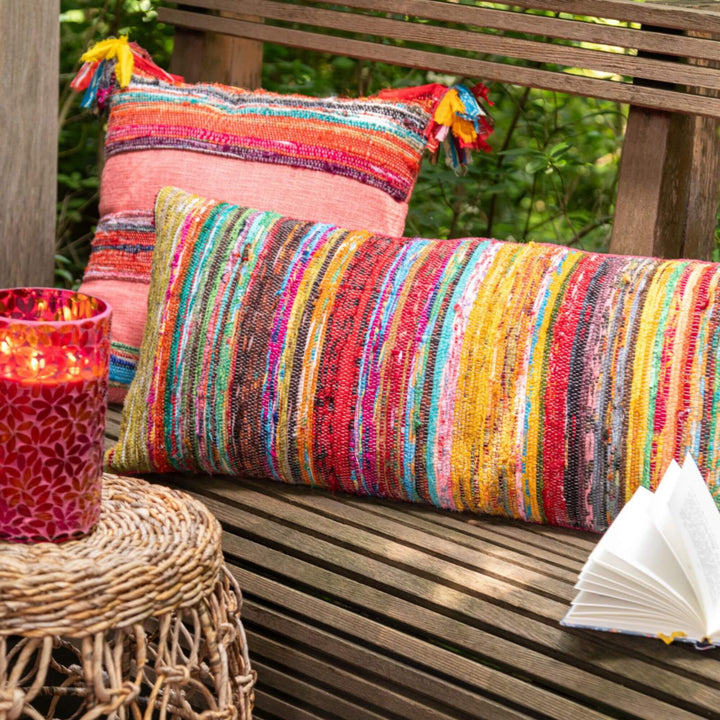 Rectangular multicolor chindi cushion with striped woven texture at an outdoor  living area 