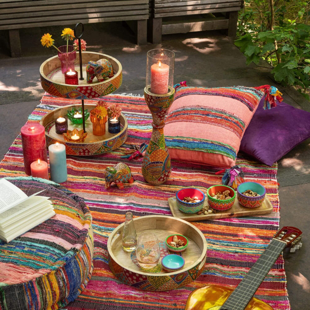 Farsha chindi plaid styled outdoors with cushions, candles, trays, and decorative accessories