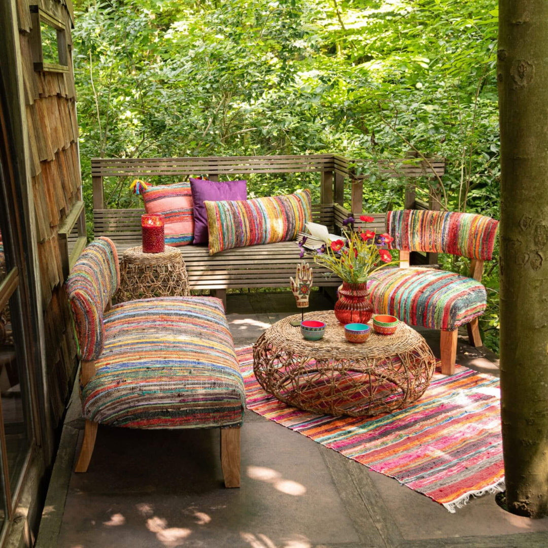 Outdoor lounge featuring the colorful Farsha Chindi Sofa on a chindi rug.