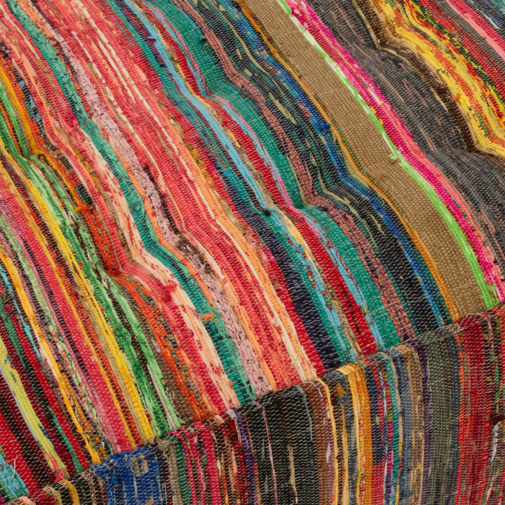 Close-up detail of multicolor chindi weave on square pouf top surface