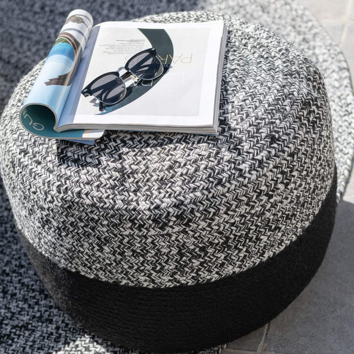 Fiona Stripe Puff used as a small side table with magazine and glasses on top.