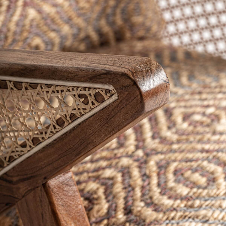 Close-up detail of teak wood armrest corner with woven rattan panel