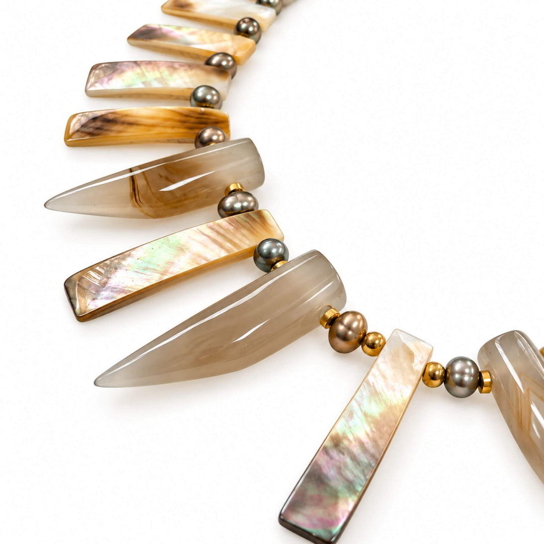 Close-up of horn-shaped agate and iridescent mother-of-pearl details on the Golden Horn Nacre Necklace
