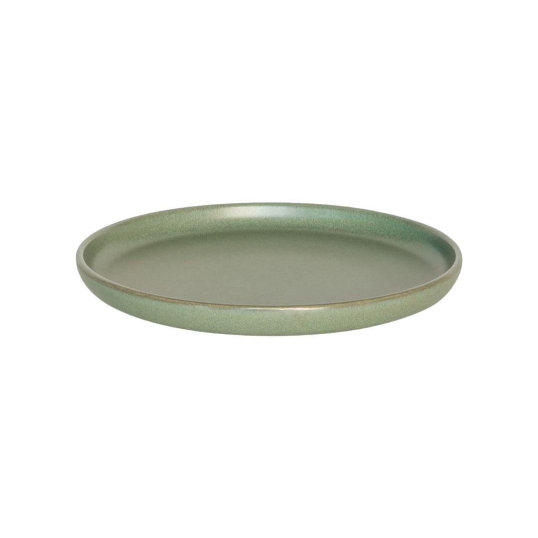 Angeled view of green ceramic plate with smooth minimalist finish.