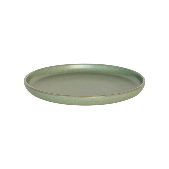 Angeled view of green ceramic plate with smooth minimalist finish.