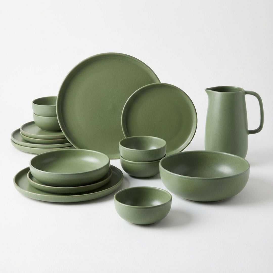 Green Amande ceramic tableware set with plates, bowls, and pitcher in soft green.