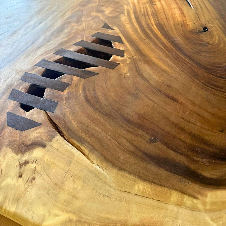 Close-up detail of the handcrafted butterfly joints embedded in the solid wood surface.