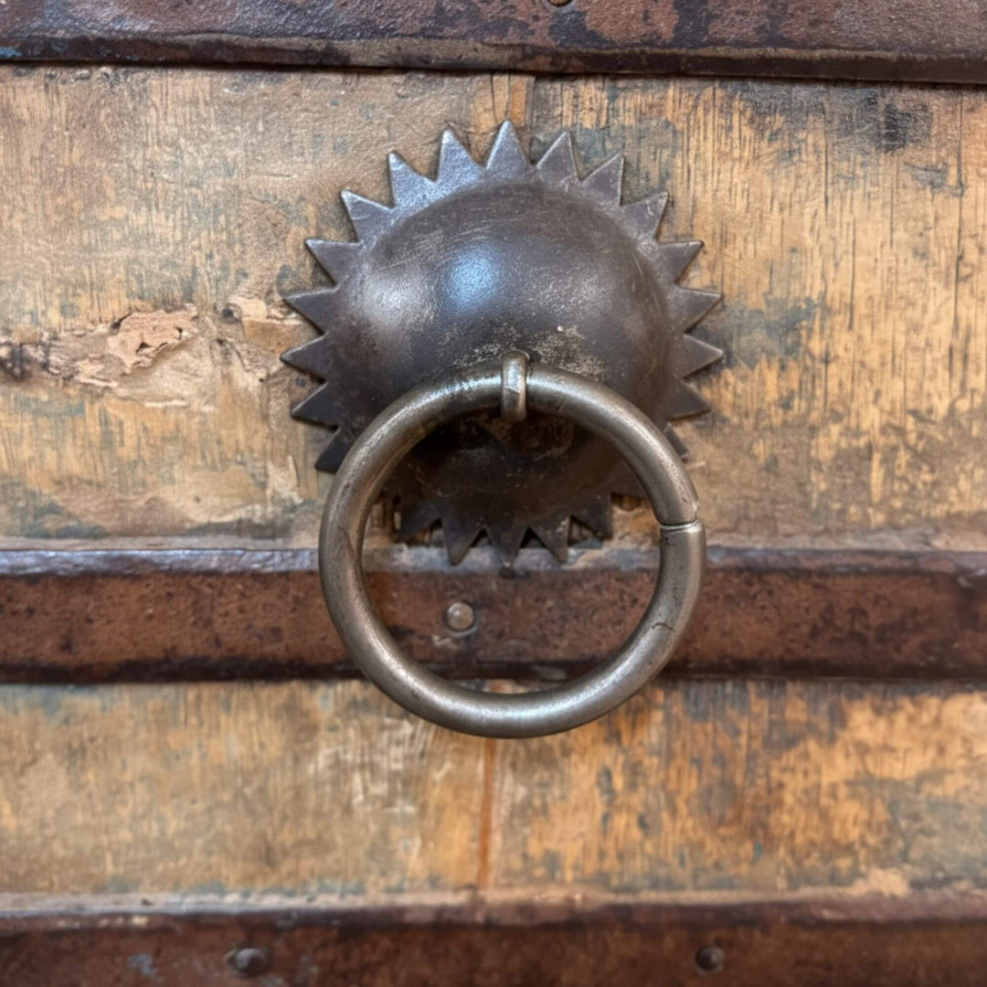 Detail of the metal ring handle and distressed teak surface.